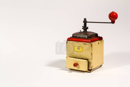 Foto de Amoladora de café manual de color madera vieja con mango rojo, sobre fondo blanco, con espacio para copiar. - Imagen libre de derechos