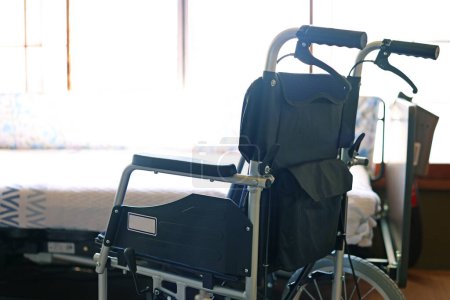 Téléchargez les photos : Petit fauteuil roulant pliant et lit électrique pour les soins infirmiers - en image libre de droit