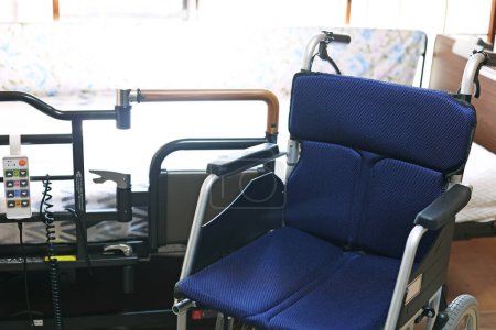 Téléchargez les photos : Petit fauteuil roulant pliant et lit électrique pour les soins infirmiers - en image libre de droit