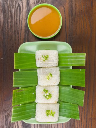 Photo for Traditional snack food from Indonesia. lemper made from rice and in containing slices of chicken meat wrapped in banana leaves - Royalty Free Image