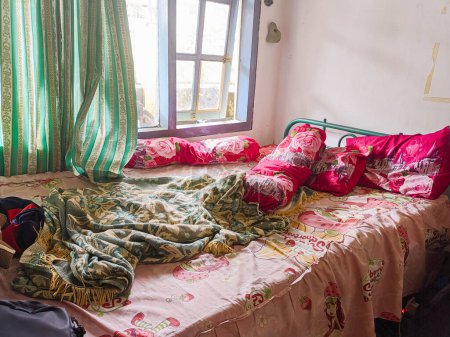Photo for The bedroom is a mess. A child's room with a messy bed and pillows, bolsters and quilts that have not been tidied up. real life. - Royalty Free Image