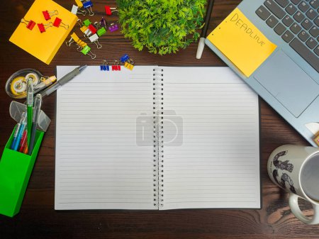 Photo for Flat lay, a mock up of a notebook. workspace in the background of the office desk from the top view. A workspace with white notebooks, laptops, office supplies, pencils, and coffee cups in the background of a wooden desk. - Royalty Free Image