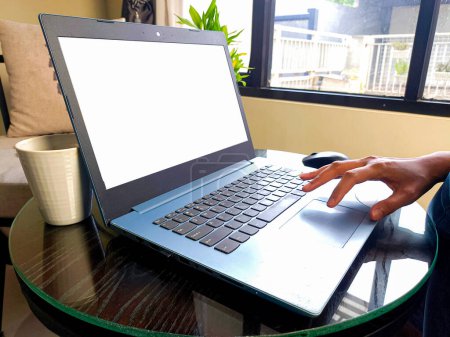 Photo for Women using laptop computer working at home with blank white desktop screen. - Royalty Free Image