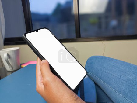 Photo for Close-up of a woman hand holding a smartphone white screen is blank .Mockup. - Royalty Free Image