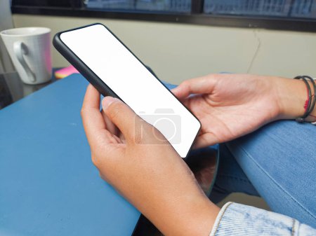 Photo for Close-up of a woman hand holding a smartphone white screen is blank .Mockup. - Royalty Free Image