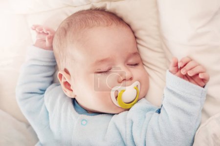 Cute three month old baby sleeping in comfortable bed. Concept of the family andparenting.