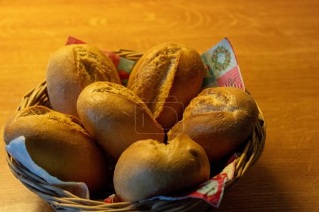 Wheat buns in the basket on the wooden table. High quality photo