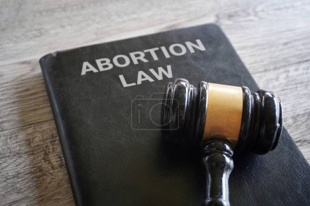 Image rapprochée du marteau du juge et livre avec texte ABORTION LAW. 