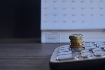 Photo for Closeup image of coins, calendar and calculator with copy space. Financial, savings and economy concept. - Royalty Free Image