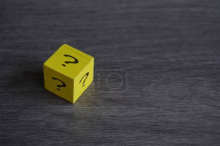Foto de Cubo de madera con signo de interrogación en la mesa con espacio para copiar. Concepto de suerte, riesgo y elección. - Imagen libre de derechos
