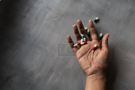 Photo for Closeup image of hand and pills on concrete floor with copy space. Overdose, drug addict and suicide concept - Royalty Free Image