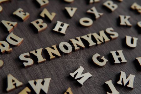 Nahaufnahme Bild von Text SYNONYMS umgeben von verstreuten Buchstaben. 
