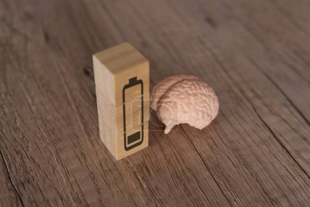 Téléchargez les photos : Image rapprochée du cerveau et des blocs de bois avec icône de batterie de faible énergie. Concept épuisé, fatigué et épuisé. - en image libre de droit
