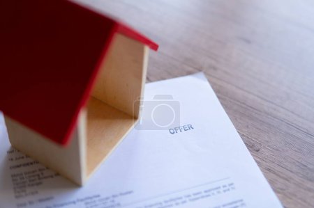 Photo for Closeup image of toy house and home financing offer letter from bank. Home ownership concept. - Royalty Free Image