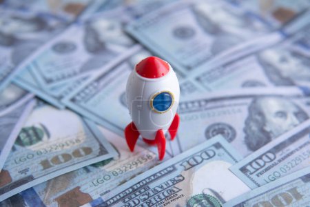 Closeup image of rocket spaceship and money. Business startup, launch and boost concept.