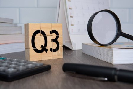 Close up image of wooden cubes with alphabet Q3 on office desk. Third quarter concept.