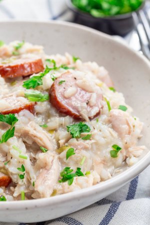 Traditional South Carolina chicken bog dish with smocked sausages, in a bowl, vertical closeup