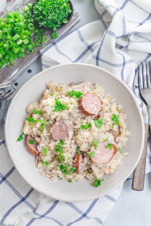 Traditional South Carolina chicken bog dish with smocked sausages, in a bowl, vertical, top view
