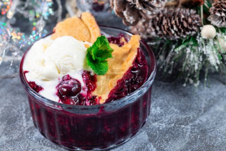 Foto de Delicioso zapatero Berry en ramekin de vidrio con helado, decoración navideña sobre fondo, horizontal - Imagen libre de derechos