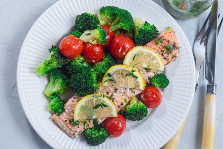Filet de saumon cuit au four avec brocoli et tomate dans une assiette, steak de saumon aux légumes, horizontal, vue sur le dessus