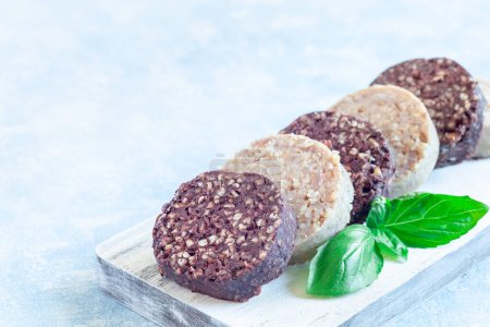 Traditional Irish and British black pudding and white or oatmeal pudding sausage on a wooden board, horizontal