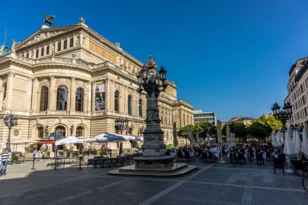Téléchargez les photos : Frankfurt, Germany - 30th September 2022: Photographer visiting Frankfurt, exploring the old opera and its surroundings at a cold but sunny day in Autumn. - en image libre de droit