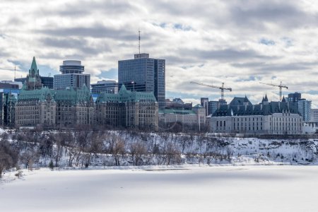 Foto de Having a walk through the Majors Hill Park in downtown Ottawa Canada with view to the historical buildings of the Canadian parliament and its surroundings at a cold but sunny day in winter. - Imagen libre de derechos