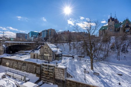 Foto de Having a walk through the Majors Hill Park in downtown Ottawa Canada with view to the historical buildings of the Canadian parliament and its surroundings at a cold but sunny day in winter. - Imagen libre de derechos