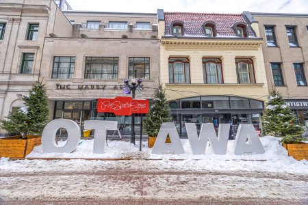 Téléchargez les photos : Ottawa, Canada - February 08th 2023: A german photographer discovering the pedestrian zone in downtown Ottawa, viewing the Ottawa sign at the so called winter lude. - en image libre de droit