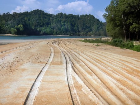 Foto de Perspectiva de vehículo 4x4 Pistas de neumáticos se vio en la arena dorada, jeeps condujeron a lo largo de la amplia playa de arena, el mar de Andamán, la montaña verde y el cielo azul en el fondo - Imagen libre de derechos