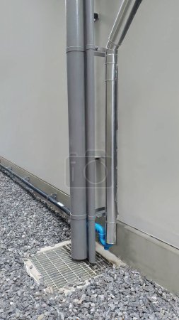 Téléchargez les photos : Drain pluvial à bec verseur et autre pipeline vertical avec trou d'homme en béton installé à l'extérieur du bâtiment, montrant le système de conception de la plomberie des égouts techniques - en image libre de droit