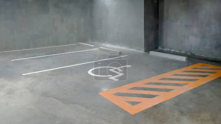 Photo for Reserve parking lot for disabled at modern building basement, international symbol or universal sign for handicapped parking painted on the concrete floor - Royalty Free Image