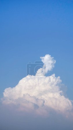Weiße flauschige Wolken offen für Fantasie Ideenform gegen strahlend blauen Himmel für Hintergrund mit Kopierraum, grafische Ressource, Wolkenbewegung vom Wind