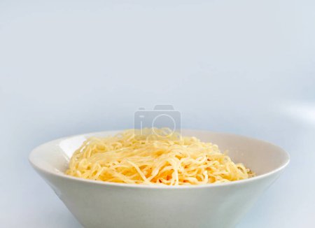 Cooked egg noodles boiled and mixed with fried garlic oil in a bowl, Asian style food, ready to eat, isolated in plain background, local food business