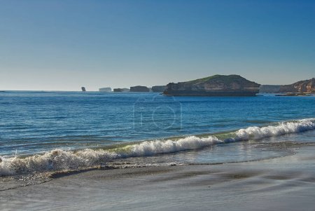 Islas hechas de roca caliza creada por la erosión del agua y silueta por el sol de la tarde en la costa sur de Victoria, Australia.