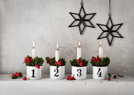 Photo for 4. Advent. Christmas decorations with white advent candles in four emaile pots with numbers. Handmade home decoration. Selective focus. Copy space. - Royalty Free Image