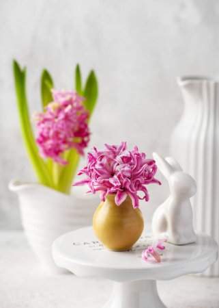 Foto de Spring floristic arrangement with pink hyacinth flowers in a small vase for Eastern. Pastel vintage style. Selective focus. Copy space. - Imagen libre de derechos