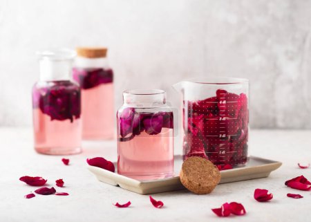 Homemade rose petal water or syrup, made with fresh organic roses. Healthy summer food concept. Selective focus.