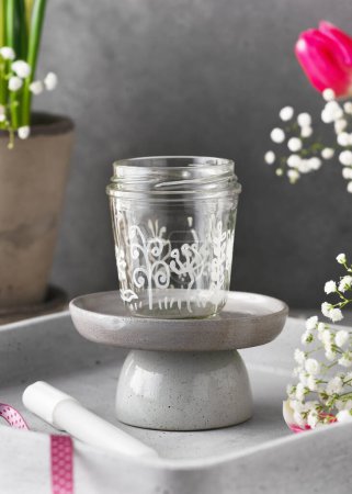 Téléchargez les photos : Petit vase en verre peint à la main avec différents motifs de fleurs. Cadeau fait à la main ou décor en verre recyclé. Concept d'artisanat pour enfants facile et amusant. Concentration sélective - en image libre de droit