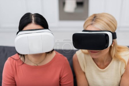 Photo for Friends in vr headsets spending time together at home - Royalty Free Image