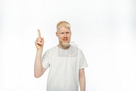 Téléchargez les photos : Homme barbu albinos en t-shirt souriant tout en montrant geste idée sur fond blanc - en image libre de droit