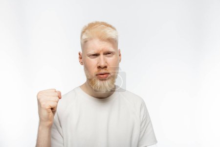 Photo pour Homme barbu albinos en t-shirt avec poing serré sur fond blanc - image libre de droit