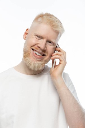 happy albino man in t-shirt talking on smartphone and smiling isolated on white 