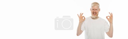 happy albino man in t-shirt showing ok sign with hands isolated on white, banner 