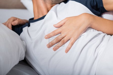 Téléchargez les photos : Cropped view of woman touching boyfriend on bed - en image libre de droit