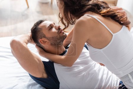 Téléchargez les photos : Brunette woman hugging sexy boyfriend on bed - en image libre de droit