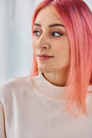 attractive joyous woman with pink vibrant hair in casual white jumper posing and looking away