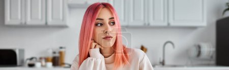 Photo for Beautiful jolly woman with pink vibrant hair in homewear looking away while in kitchen, banner - Royalty Free Image