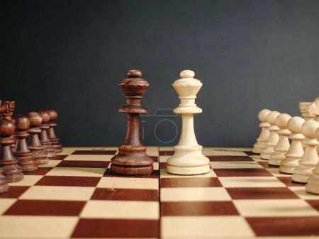 Schach auf schwarzem Hintergrund Schach Dame gegenüber auf dem Schachbrett mit dem Rest der Figuren. Hochwertiges Foto