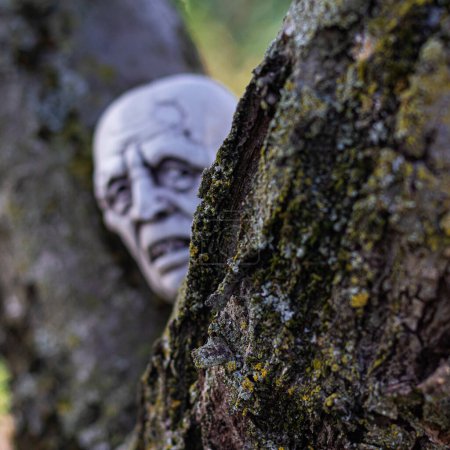Photo for Undead into your Halloween festivities with this meticulously crafted plastic zombie head, eerily lifelike amidst the moonlit, overgrown lawnan embodiment of spine-tingling fear - Royalty Free Image